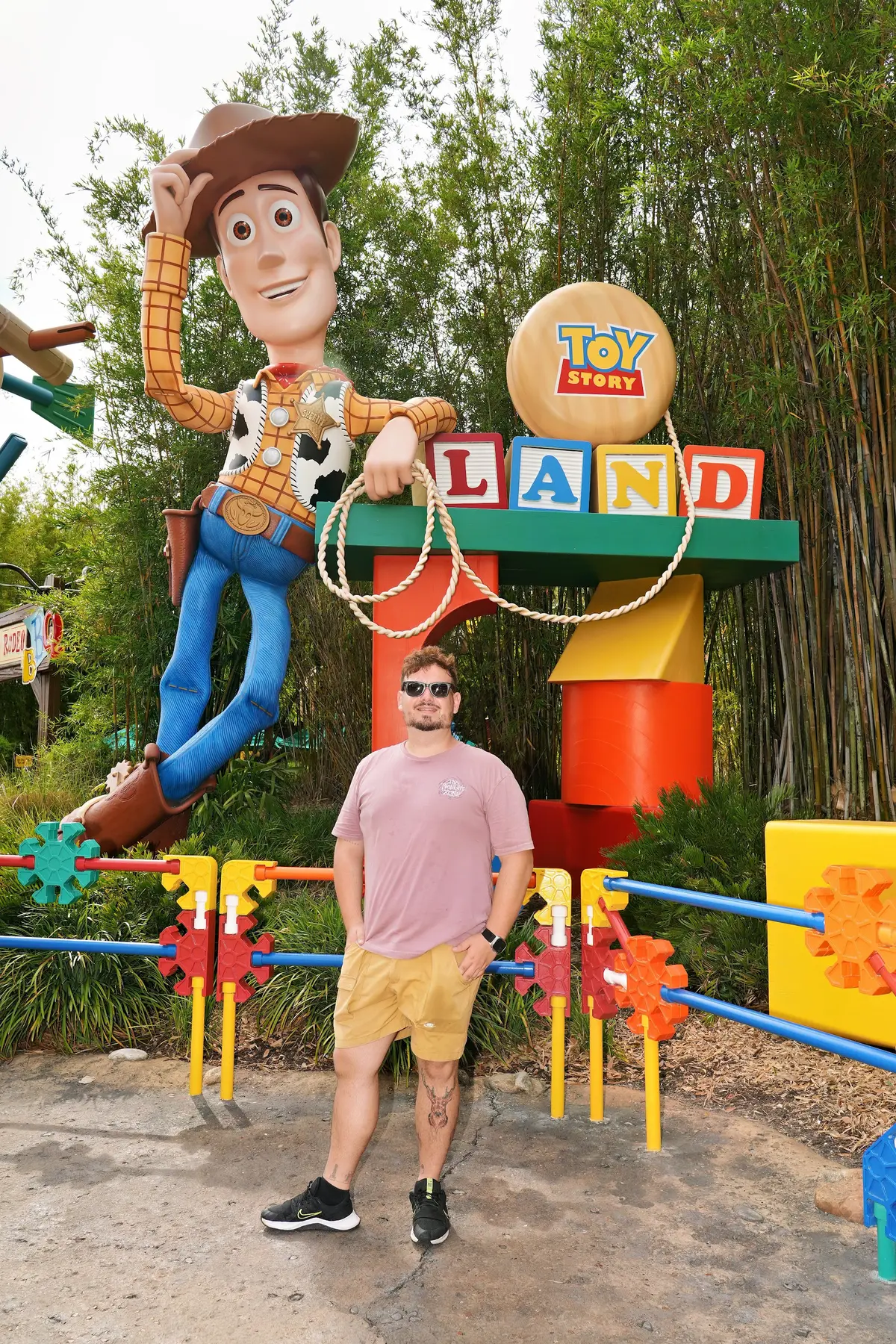 Thomaz diante do Woody gigante e do letreiro de entrada da Toy Story Land, no Hollywood Studios
