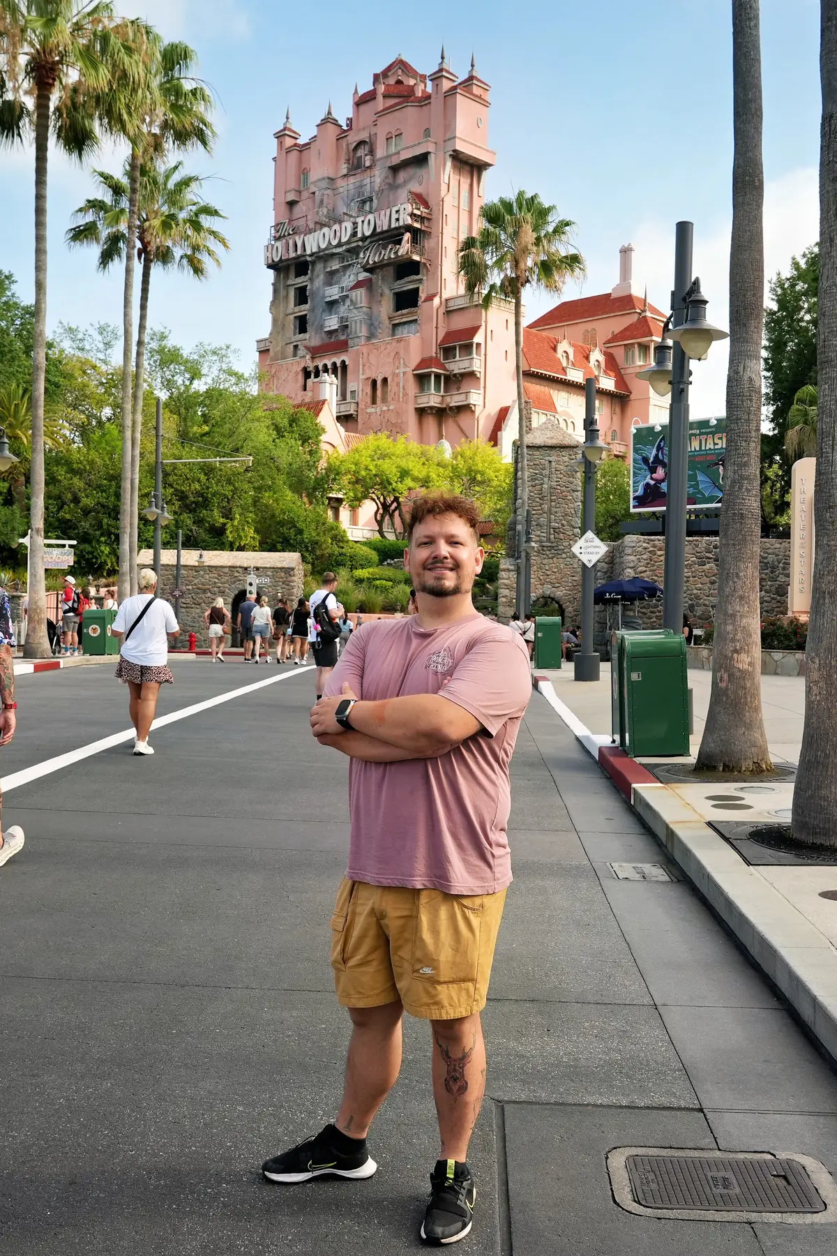 Thomaz, da Desenrola, de braços cruzados na Sunset Boulevard, com a Tower of Terror ao fundo, no Hollywood Studios