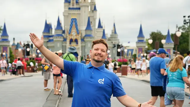 Thomaz, da Desenrola, de braços abertos na Main Street do Magic Kingdom, com o Castelo da Cinderela ao fundo