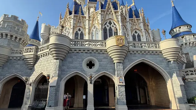 Castelo da Cinderela sob céu azul, com a praça da frente vazia, em foto grande-angular no Magic Kingdom