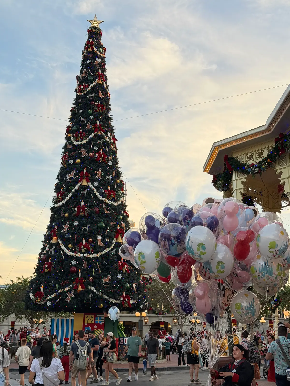 Árvore de Natal gigante e balões de personagens na Main Street do Magic Kingdom, decorada para as festas de fim de ano