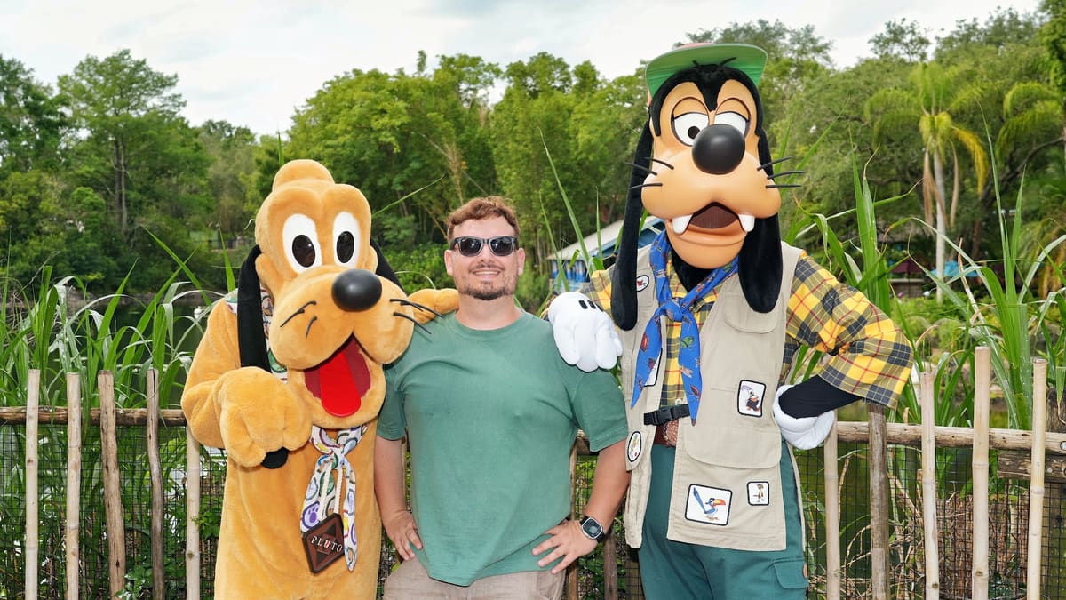 Thomaz com Pluto e Pateta em trajes de safári num encontro com personagens no Animal Kingdom, em Orlando