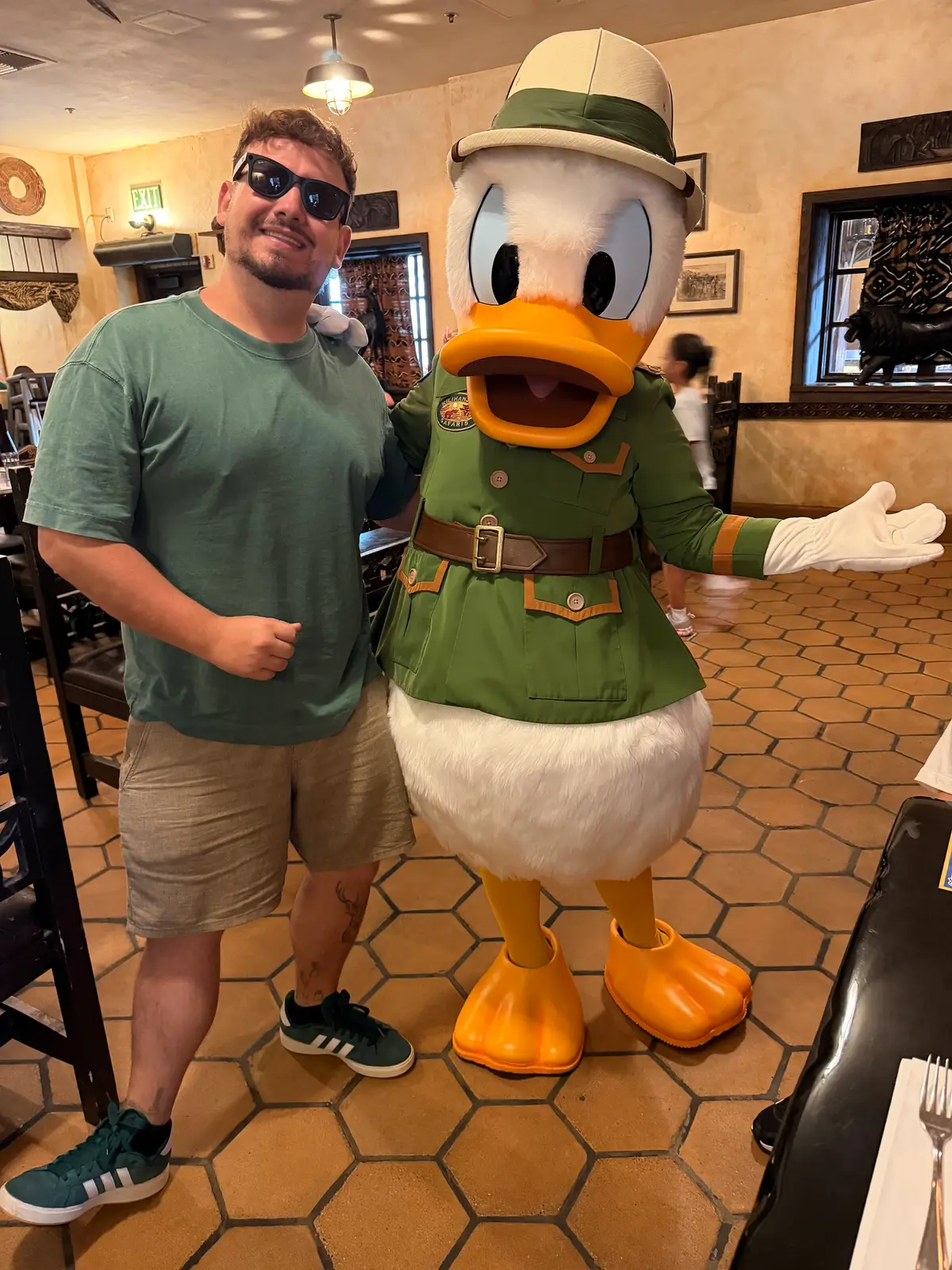 Thomaz com o Pato Donald em traje de safári no salão do restaurante Tusker House, no Animal Kingdom