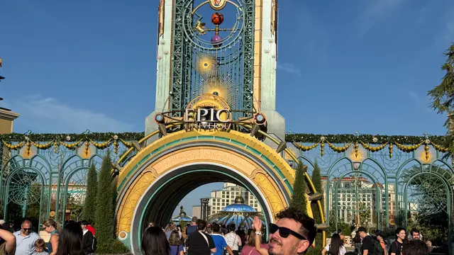 Thomaz, da Desenrola, de braços cruzados diante do portal de entrada do Epic Universe, na Universal Orlando