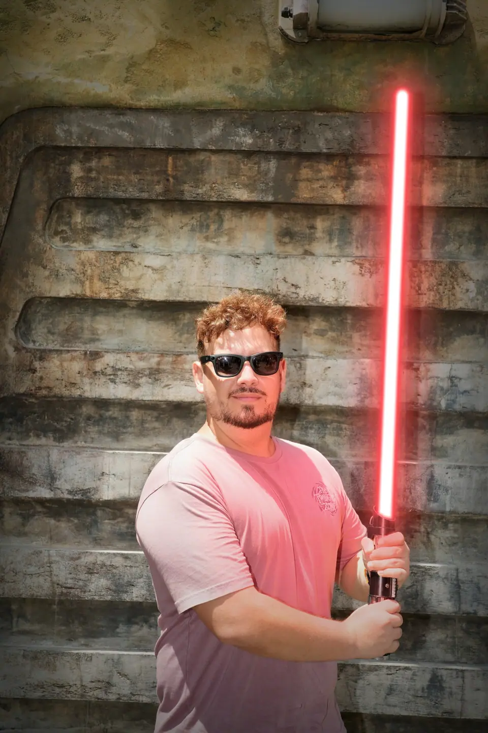 Thomaz, guia da Desenrola, com um sabre de luz na área de Star Wars do Hollywood Studios